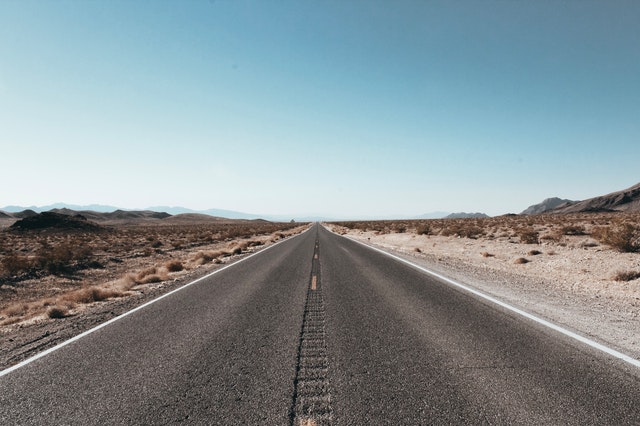 silnice v poušti, opuštěná vozovka kolem písčité pláně